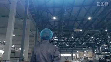 女工业工人走过制造工厂的镜头。剪辑。女仓库工人穿制服的后视图.
